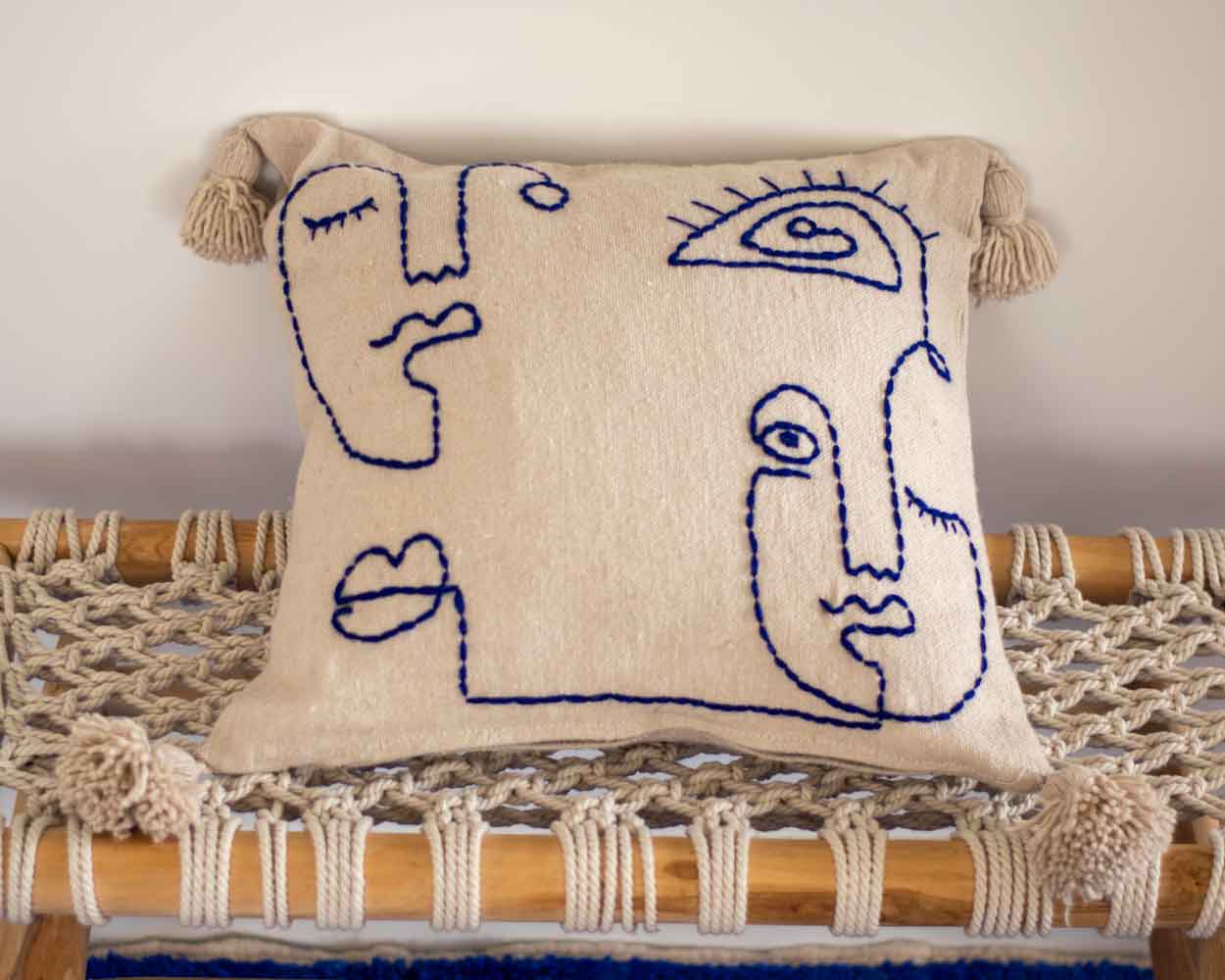 Beige cushion cover with blue embroidered patterns