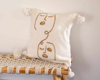 White cushion cover with beige embroidered patterns